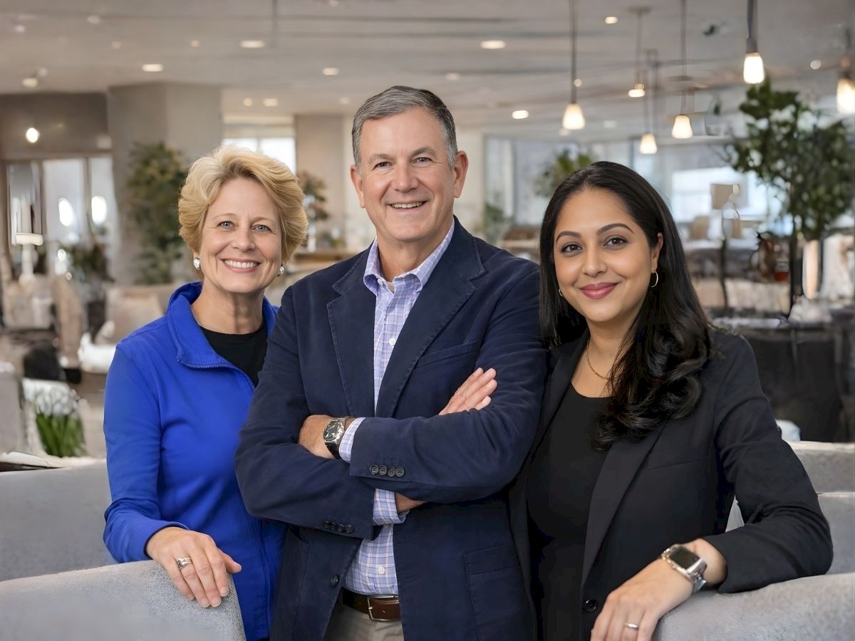 A cheerful trio of business professionals posing confidently in a modern office lounge, ready for collaboration and success.
